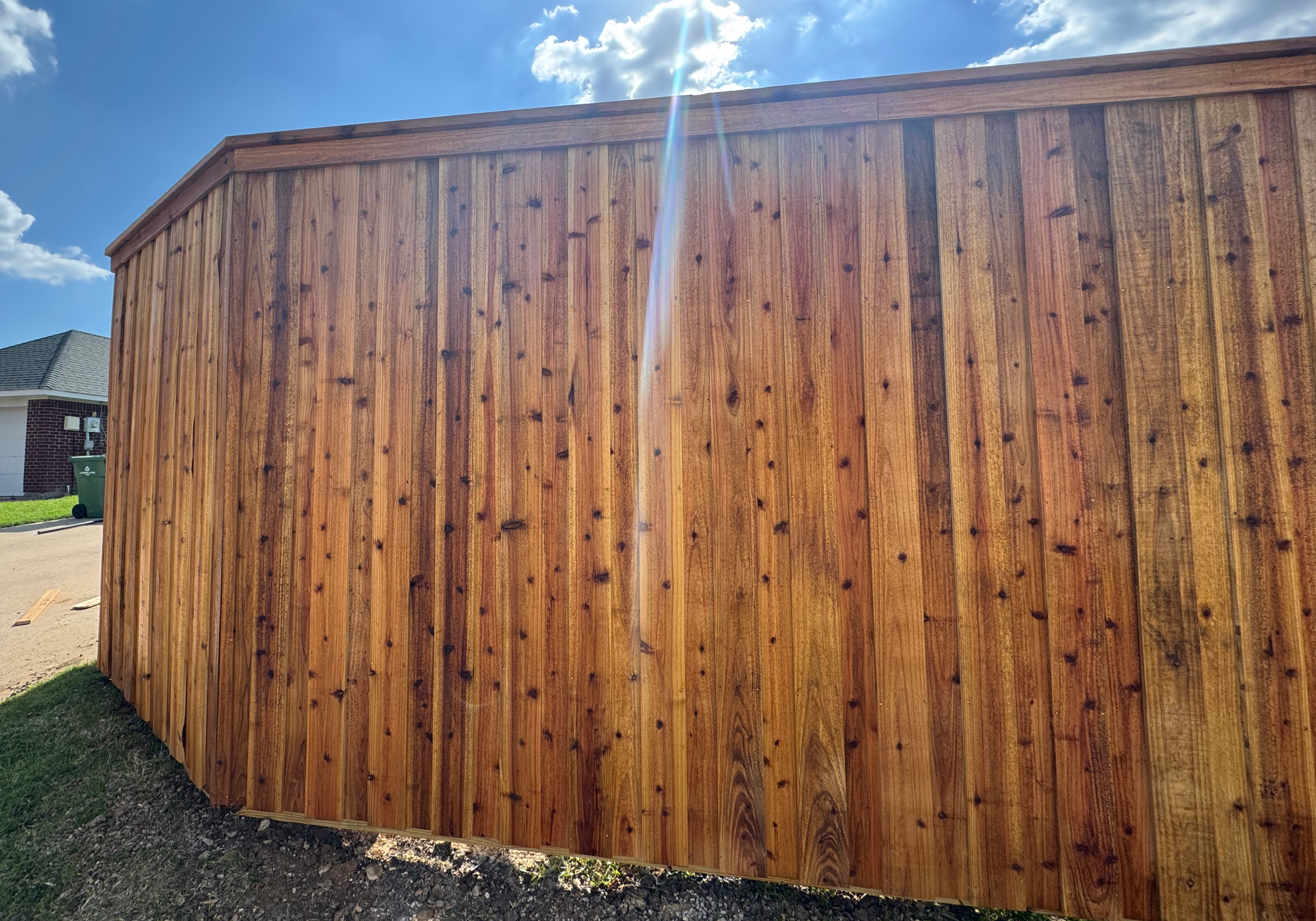 "A recently installed 8ft board-on-board vertical cedar fence showcasing its rich color and natural grain, providing privacy and enhancing the outdoor aesthetic